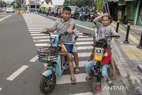 Aksi bocah mengendarai motor listrik di jalan raya