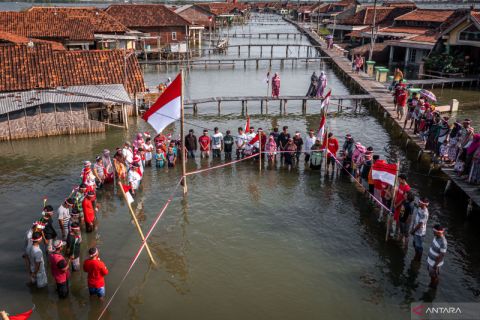 Upacara bendera di tengah banjir rob