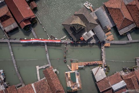 Upacara bendera saat banjir rob di pesisir Demak