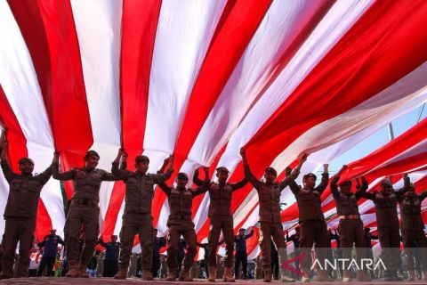 Pembentangan bendera Merah Putih di anjungan pantai Losari Makassar  