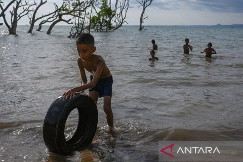 Anak-anak manfaatkan masa libur panjang kenaikan kelas dengan bermain di pantai