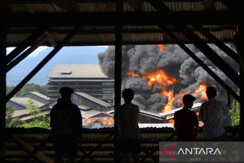 Kobaran api dan ledakan terdengar saat pabrik karet yang berada sekitar pemukiman terbakar