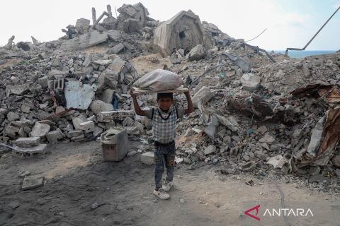 Anak-anak di Gaza mencari kayu bakar di tengah puing-puing reruntuhan