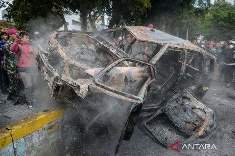 Evakuasi bangkai mobil yang terbakar saat aksi unjuk rasa penabrakan ojek online