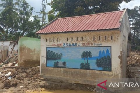 Dinding yang masih mengajar di tengah puing Garoga