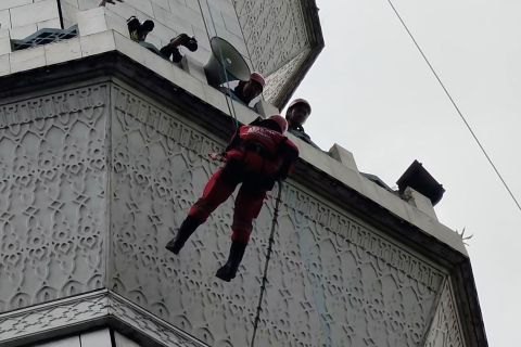 Aksi relawan dalam simulasi pembersihan menara Masjid Agung Bandung