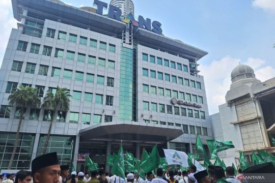 Pengunjuk rasa PWNU DKI dan alumni pesantren kibarkan bendera hijau di gedung Trans7