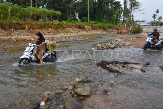 Warga menyeberangi sungai di Padang
