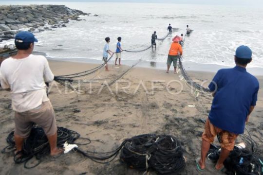 Nelayan menjaring sampah laut di Padang