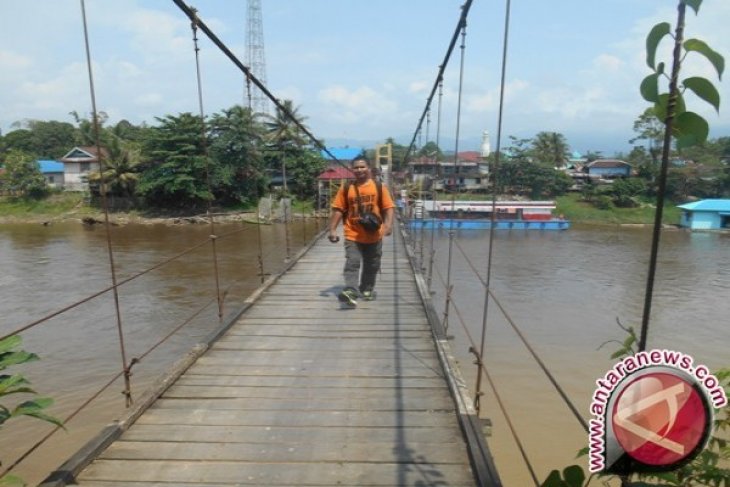 Seorang warga sedang melintas di di Jembatan Gantung Merdeka, di Kecamatan Tabang, Kutai Kartanegara