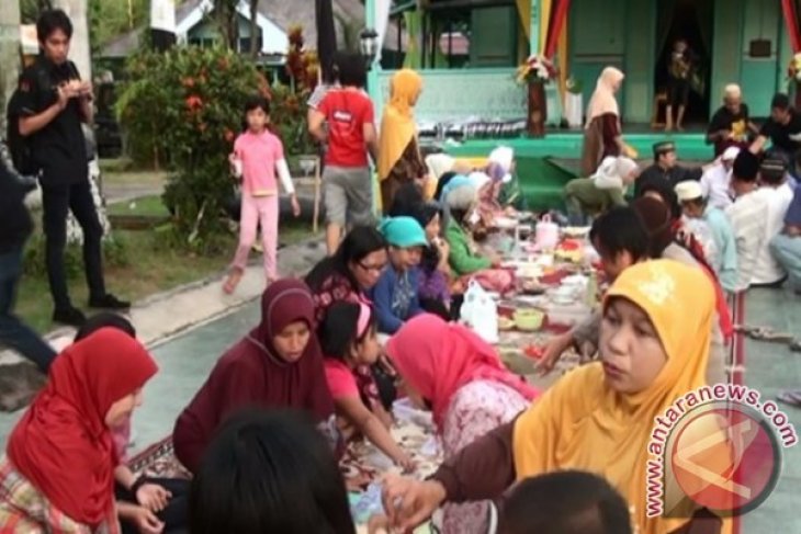 Traditional Robo-robo participants in Mempawah, wearing traditional attire and carrying offerings