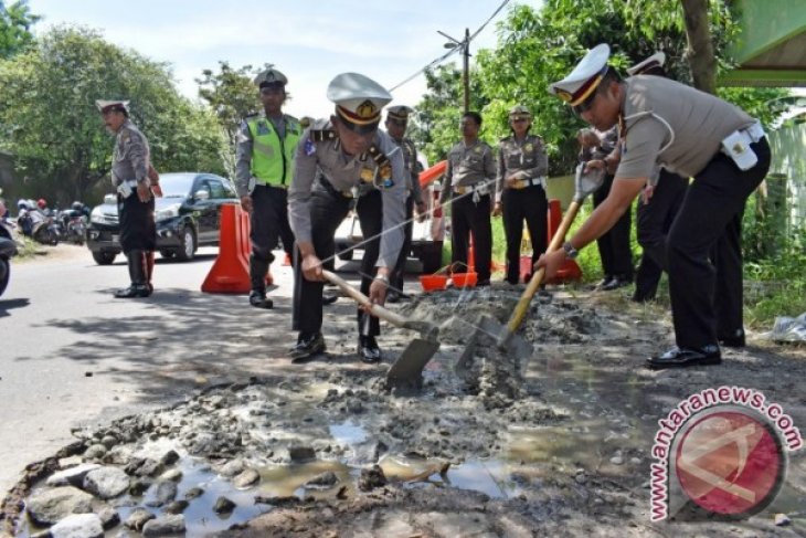 Polisi Tambal Jalan Berlubang