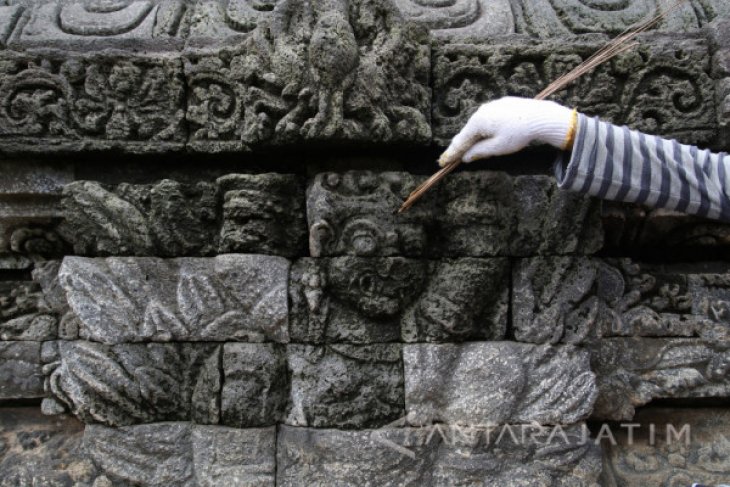  Pekerja dari Balai Pelestarian Cagar Budaya Trowulan membersihkan lumut yang tumbuh di relief candi Tegowangi di Desa Tegowangi, Kediri, Jawa Timur, Kamis (11/1). Candi yang dibangun oleh Kerajaan Majapahit sekitar tahun 1400 masehi tersebut pada saat mu