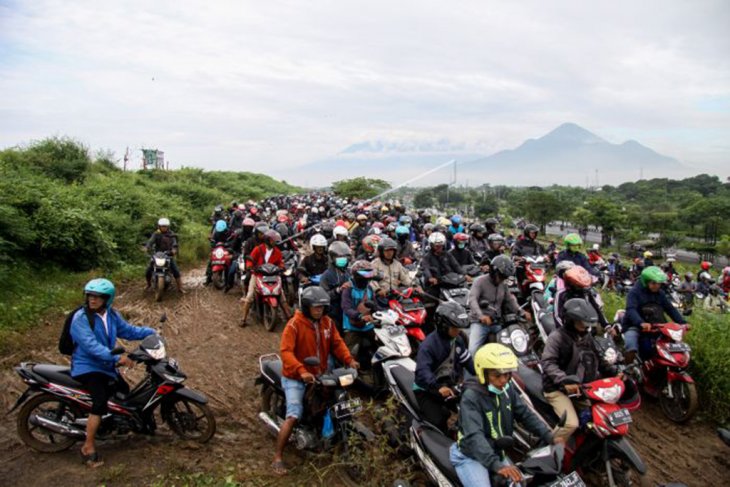 Pengendara motor menghindari banjir Porong