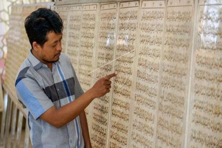 Ukiran huruf Al Quran di batu marmer
