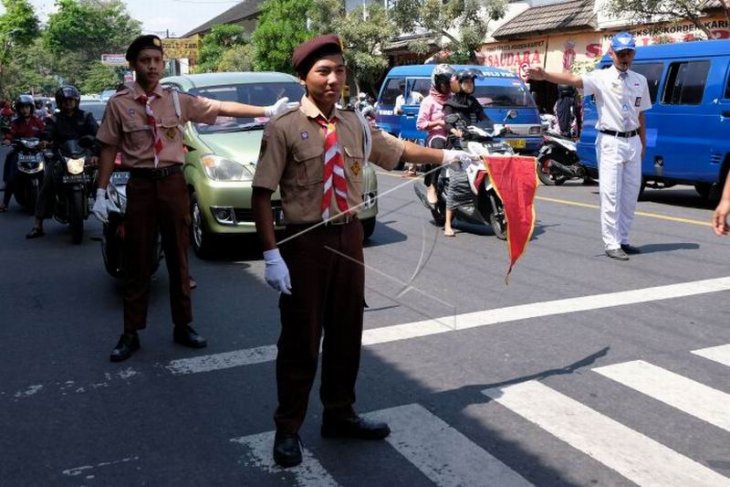 Pramuka membantu mengatur lalu lintas