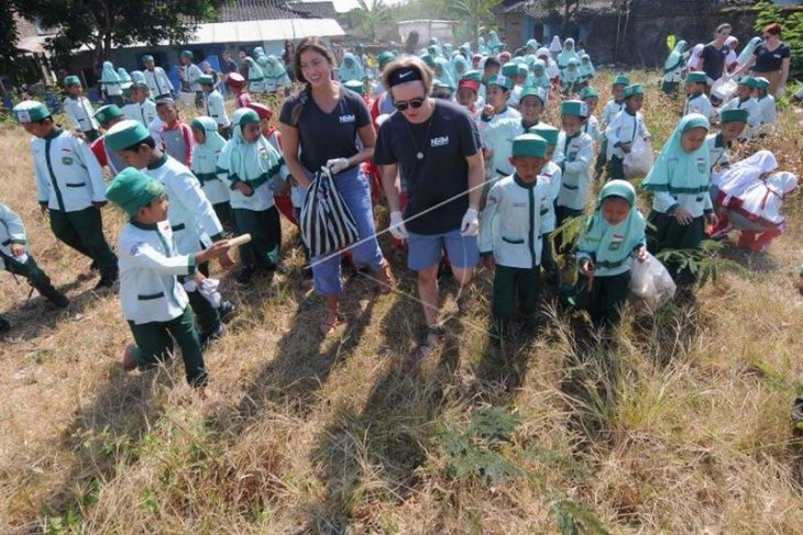 Relawan asing membersihkan sampah