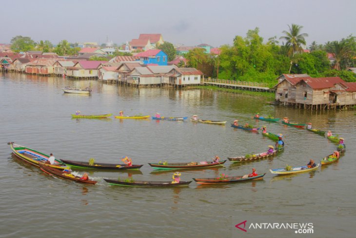 Pedagang Pasar Terapung Melakukan Atraksi