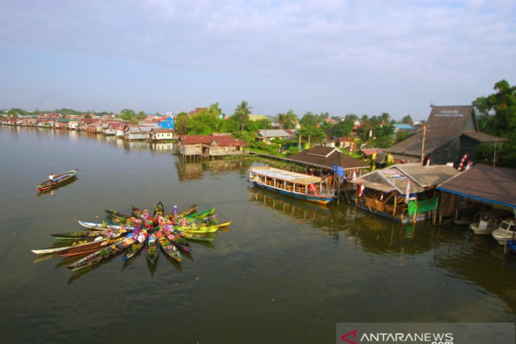 Pedagang Pasar Terapung Melakukan Atraksi