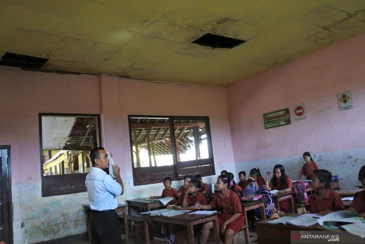 Siswa belajar di kelas rusak