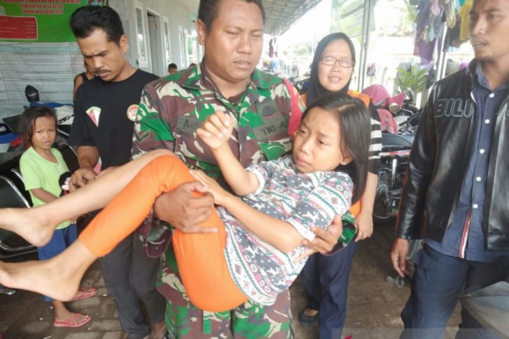 Anggota TNI evakuasi korban banjir di Kibin, yang terserempet motor