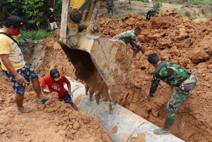 Tentara dan warga saling membantu memasang gorong-gorong