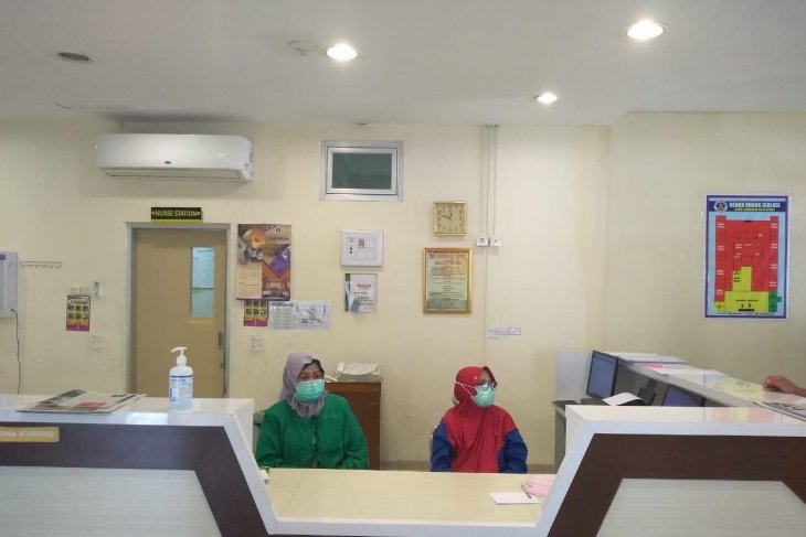 Perawat di ruang isolasi pompa semangat pasien agar sembuh