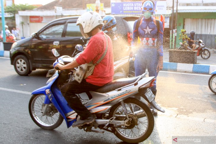 Superhero semprotkan cairan disinfektan