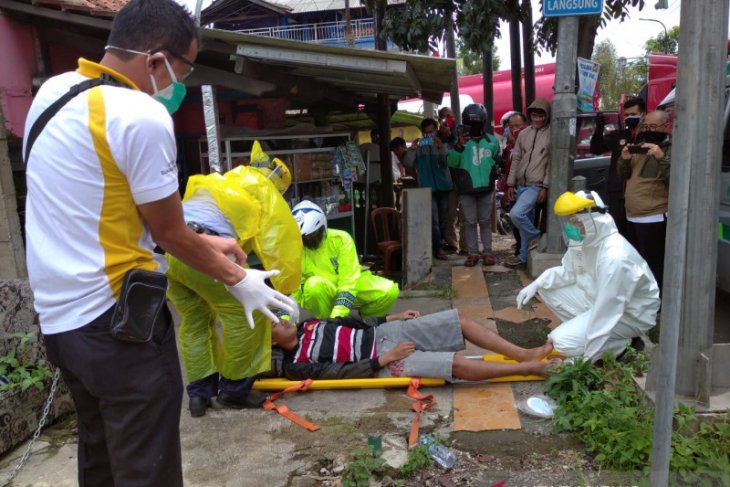 Kenakan jas hujan sebagai APD Polantas Sukabumi evakuasi warga terkapar