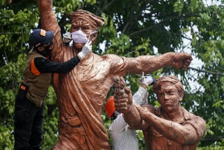 Memasang masker di patung Monumen Djoeang 45