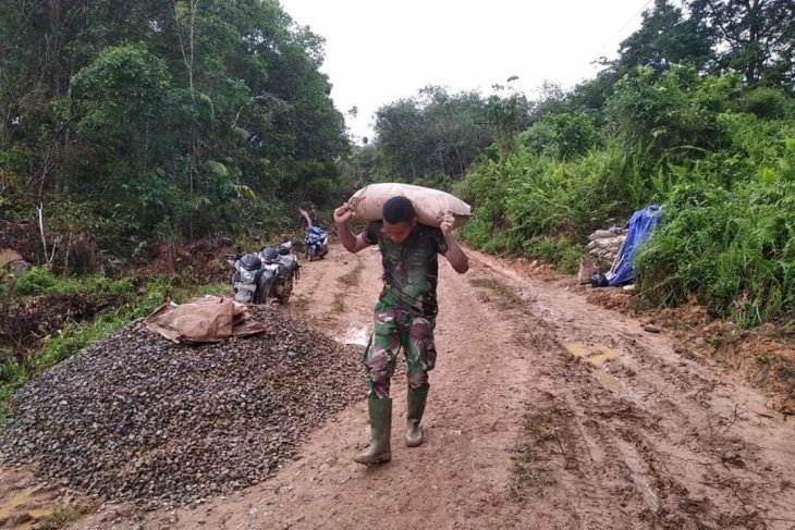 Anggota TMMD berjibaku angkut semen mengunakan bahunya