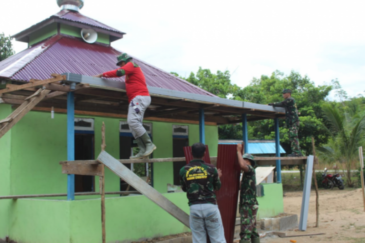 Anggota TMMD pasang talang air Mushola At Taqwa