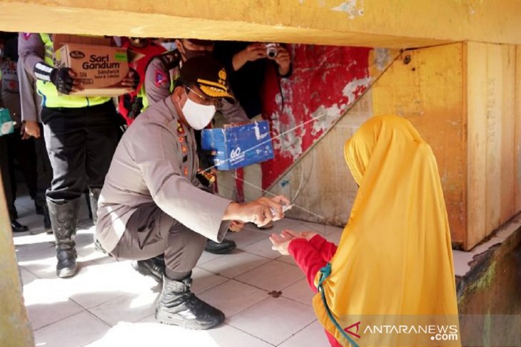 Foto - Kapolda Gorontalo semprotkan hand sanitizer ke warga di pasar Sentral