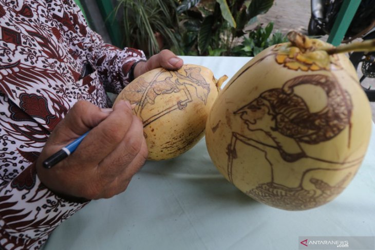 Perajin  gambar wayang pada kelapa