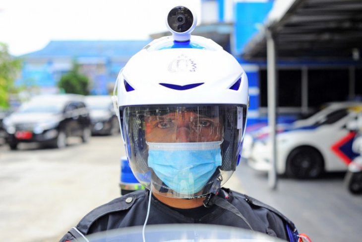 Polisi lalu lintas  mengenakan helm berkamera portabel untuk berpatroli