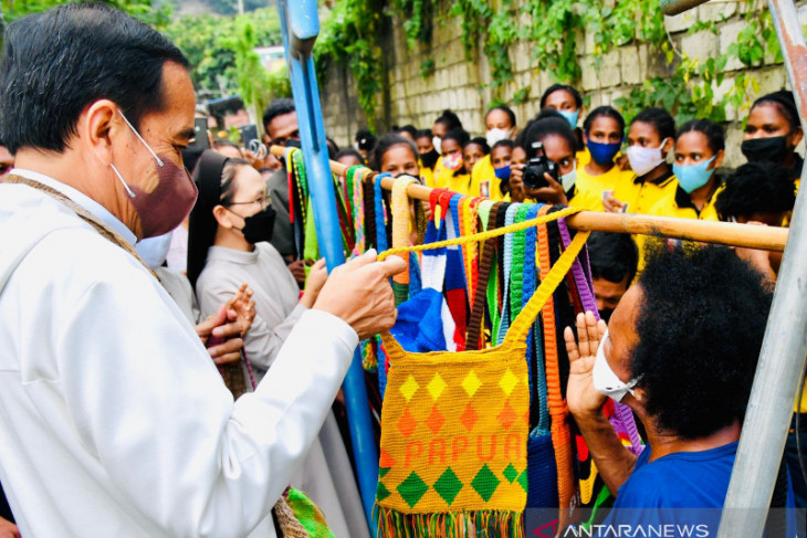 After arriving at Sentani airport, President stops to buy noken