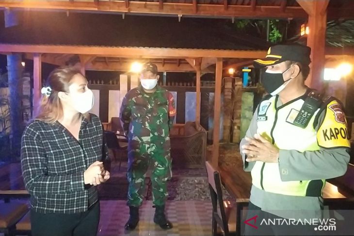 Petugas gabungan sosialisasi vaksinasi dan jam operasional kafe