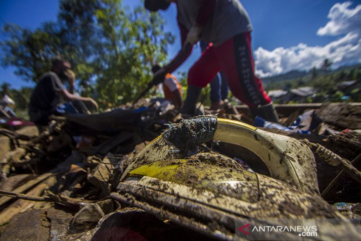 Membersihkan Sampah Sisa Luapan Sungai Hantakan