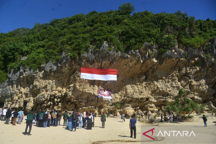 Pengibaran bendera raksasa di tebing terjal Aceh Besar