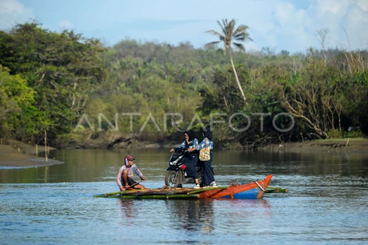 Pelajar dengan sepeda motornya menyeberangi kali Mantiung menuju sekolah