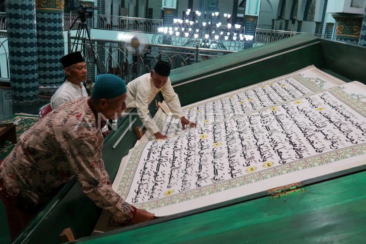Petugas membalik lembaran Al Quran raksasa di Masjid Agung Baiturrahman