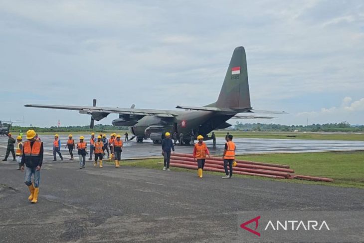 Petugas PLN bersama personel TNI memasukkan material ke pesawat Hercules