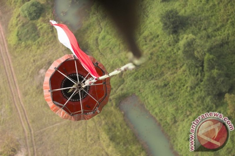 Helikopter BNPB Kibarkan Bendera Merah Putih