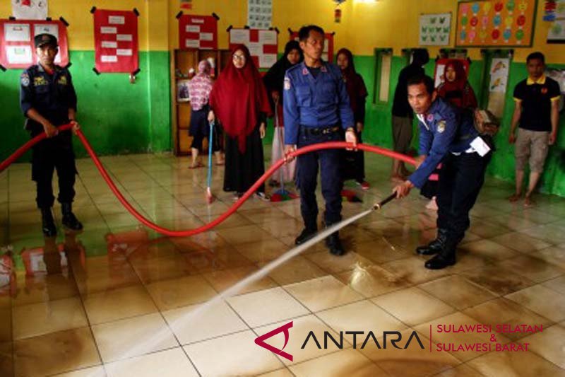 Membersihkan sekolah dari lumpur banjir