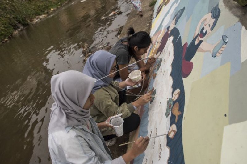 Melukis mural Cau Pisun di Kirmir Sungai Cikapundung