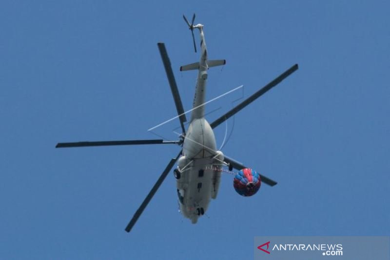 HELIKOPTER TUMPAHKAN AIR DIKERUMUNAN MASSA