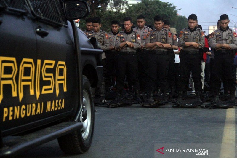 Polisi sholat berjamaah saat amankan demo