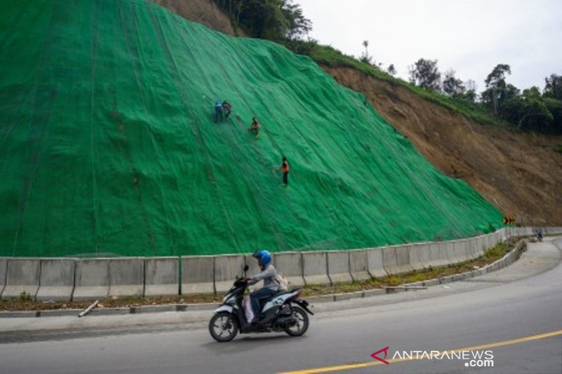 Pekerja memasang geogrid biaxial pada proyek rehabilitasi Jalan Trans Sulawesi