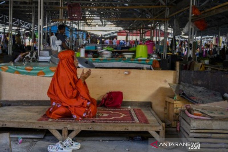 Sepi pengunjung, seorang pedagang  jalani sholat di los pasar Masomba