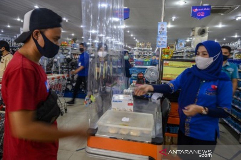 Kasir kenakan masker melayani pengunjung pusat perbelanjaan di Palu